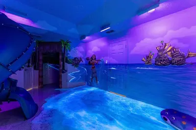 a room with a water slide in a water park at EPIC Theme 9D 360 Rotating Virtual Reality Machine 4 mi to Disney in Kissimmee