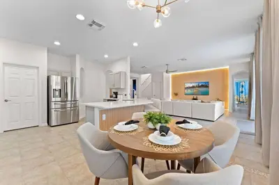 a kitchen and dining room with a table and chairs at EPIC Theme 9D 360 Rotating Virtual Reality Machine 4 mi to Disney in Kissimmee