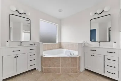 a white bathroom with a tub and two mirrors at EPIC Theme 9D 360 Rotating Virtual Reality Machine 4 mi to Disney in Kissimmee