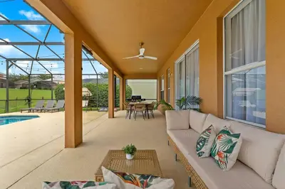a living room with a white couch and a pool at EPIC Theme 9D 360 Rotating Virtual Reality Machine 4 mi to Disney in Kissimmee