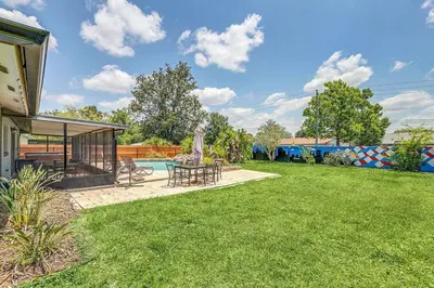 a backyard with a table and chairs and a pool at Tranquil Oasis 4BR Pool Home in Orlando