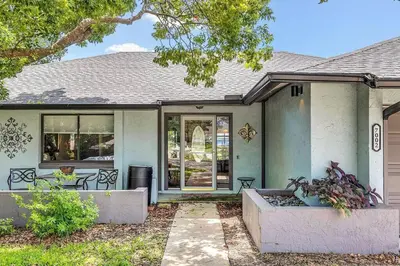 a blue house with a table and chairs in front of it at Tranquil Oasis 4BR Pool Home in Orlando