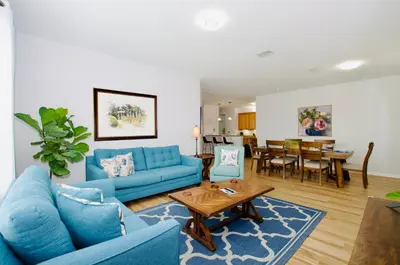 a living room with blue couches and a table at Vista Cay at Epic Universe - Luxury 4 bedroom Condo in Orlando