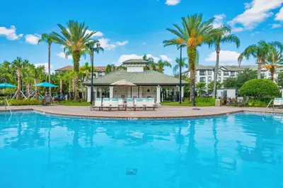 a pool at a resort with palm trees at Vista Cay at Epic Universe - Luxury 4 bedroom Condo in Orlando