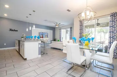 a dining room and living room with a dining table at Stunning 5Bd with Pool at Storey Lake 5019 in Kissimmee