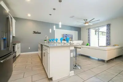 a kitchen and living room with a couch and a table at Stunning 5Bd with Pool at Storey Lake 5019 in Kissimmee
