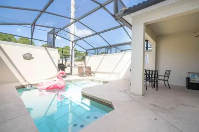 a swimming pool with a pink flamingo in the water at Stunning 5Bd with Pool at Storey Lake 5019 in Kissimmee