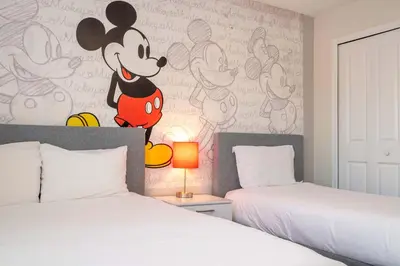 a bedroom with two beds and a mickey mouse mural at Stunning 5Bd with Pool at Storey Lake 5019 in Kissimmee