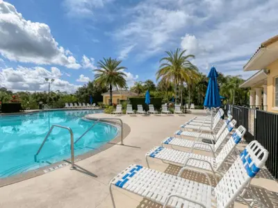 a pool with lounge chairs and umbrellas at Disney Paradise-Family Friendly- Near to Disney in Orlando
