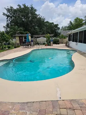 a swimming pool with blue water in a yard at Pretige Studio in Orlando