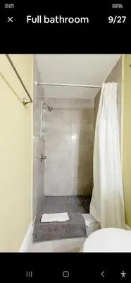 a bathroom with a shower with a white shower curtain at Pretige Studio in Orlando