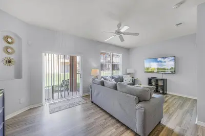a living room with a couch and a ceiling fan at Camaro in Orlando