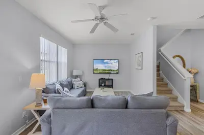 a living room with a couch and a ceiling fan at Camaro in Orlando
