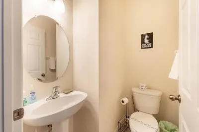a bathroom with a sink and a toilet and a mirror at Amazing Star Wars & Disney Vr Gaming House! in Kissimmee