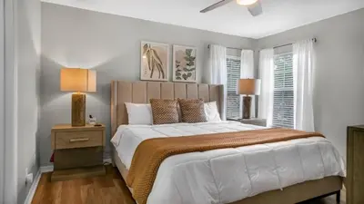 a bedroom with a large bed and two windows at Lovely 7 Bed Pool Home with Game Room-8510PHD home in Kissimmee