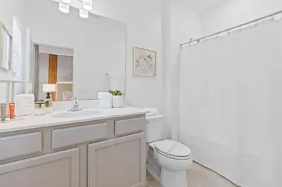a white bathroom with a toilet and a shower at Brand NEW 12Bed12Bath At Paradiso Grande in Orlando