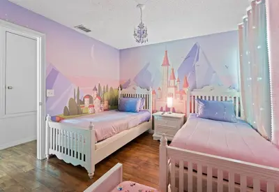 a bedroom with two beds with a disney castle mural at 7BR Family Friendly Resort Pool Home Near Disney World in Kissimmee
