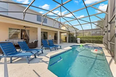 a swimming pool with blue chairs and a house at 7BR Family Friendly Resort Pool Home Near Disney World in Kissimmee