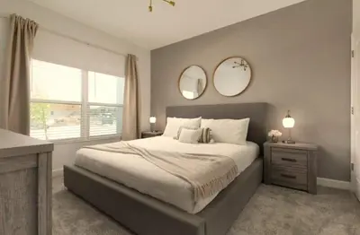 a bedroom with a large bed with two mirrors on the wall at Your 4-Bedroom Getaway, Only 9 Miles from Disney in Kissimmee