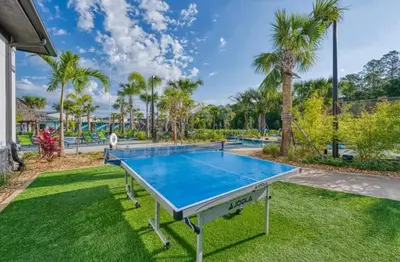a ping pong table in a backyard with palm trees at Your 4-Bedroom Getaway, Only 9 Miles from Disney in Kissimmee