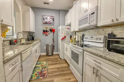 a kitchen with white cabinets and a refrigerator at Amazing Condo in Windsor Hills Close to Disney in Orlando