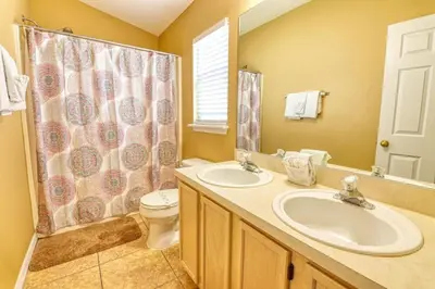 a bathroom with two sinks and a toilet and a shower at 9 Miles to Disney - Family Friendly - Private Pool in Orlando