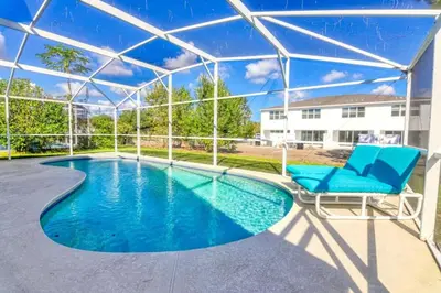 a swimming pool with a blue chair and a swimming poolvisor at 9 Miles to Disney - Family Friendly - Private Pool in Orlando