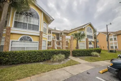 a large yellow house with a car parked in front of it at CM3 SW030-2F in Kissimmee