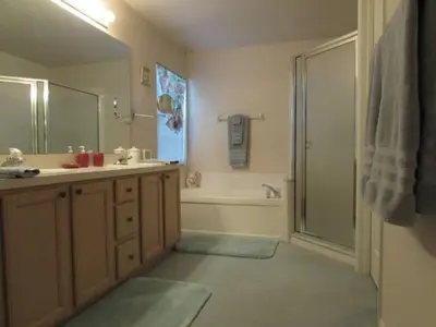 a bathroom with a shower and a sink and a tub at Creekside Kissimmee in Kissimmee