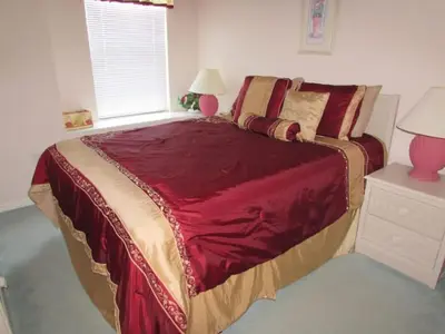 a bedroom with a large bed with a red blanket at Creekside Kissimmee in Kissimmee