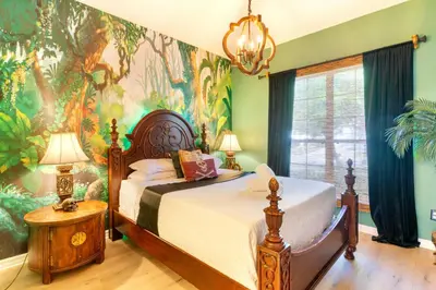 a bedroom with a bed with a jungle themed wall at VR Jungle 2 Jungle with Disney's Tarzan and MORE in Kissimmee