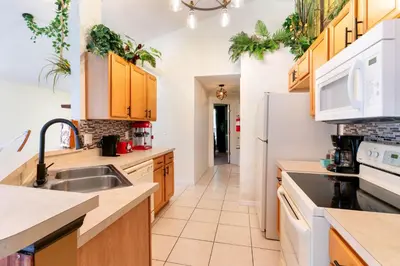 a kitchen with white appliances and wooden cabinets at VR Jungle 2 Jungle with Disney's Tarzan and MORE in Kissimmee