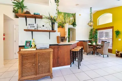a kitchen with yellow walls and a counter and chairs at VR Jungle 2 Jungle with Disney's Tarzan and MORE in Kissimmee