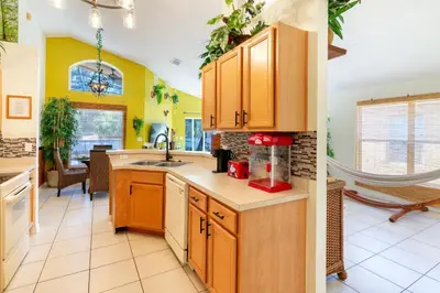 a kitchen with yellow walls and wooden cabinets at VR Jungle 2 Jungle with Disney's Tarzan and MORE in Kissimmee