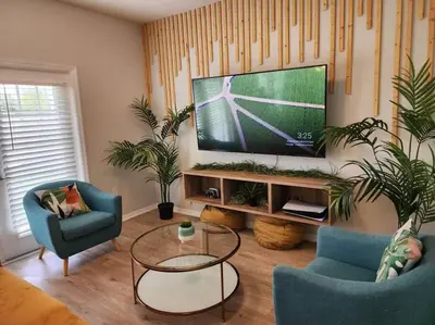 a living room with a tv and two chairs and a table at Tropical Getaway with Xbox & PS5 Gaming Paradise in Kissimmee
