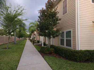 a sidewalk in front of a house with trees at Tropical Getaway with Xbox & PS5 Gaming Paradise in Kissimmee