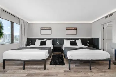 two beds in a room with white walls and windows at Studio Close to Universal Intl Drive in Orlando