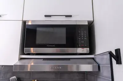 a microwave above a stove in a kitchen at Studio Close to Universal Intl Drive in Orlando