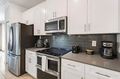 a kitchen with white cabinets and stainless steel appliances at 4327 Create Memories in a Magical 5BD Home in Kissimmee