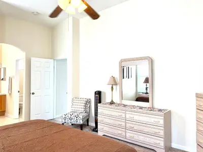 a bedroom with a bed and a dresser with a mirror at Windsor Palm Resort 3 miles to Disney 4 Bedrooms in Kissimmee