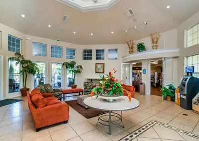 a living room with orange chairs and a table at Windsor Palm Resort 3 miles to Disney 4 Bedrooms in Kissimmee