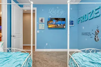 a room with a blue wall and two beds at Fairytale Retreat in Orlando