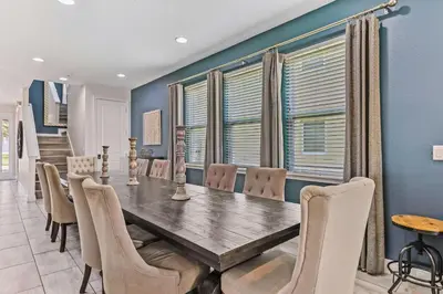 a dining room with a wooden table and chairs at Magic Manor in Orlando