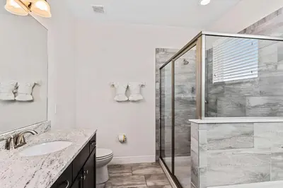 a bathroom with a shower and a sink and a toilet at Magic Manor in Orlando