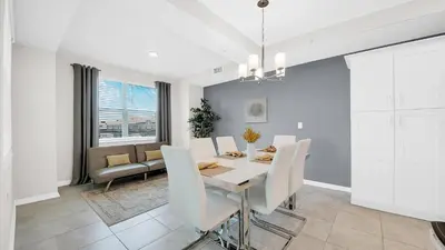 a dining room with a table and white chairs at WaterLily at Storey Lake in Orlando