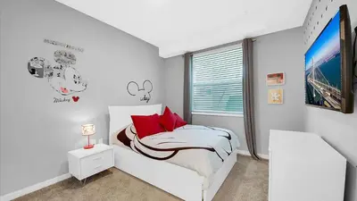 a white bedroom with a bed and a window at WaterLily at Storey Lake in Orlando