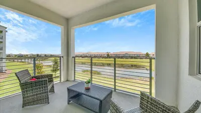 a balcony with chairs and a table with a view at WaterLily at Storey Lake in Orlando