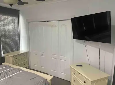 a bedroom with a bed and a television on the wall at LUXURY 6000 sqft Mansion in Downtown Orlando Sleeps 12 in Orlando