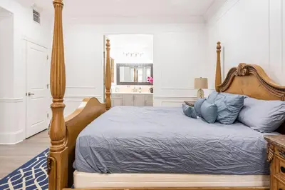 a bedroom with a large bed with blue pillows at LUXURY 6000 sqft Mansion in Downtown Orlando Sleeps 12 in Orlando
