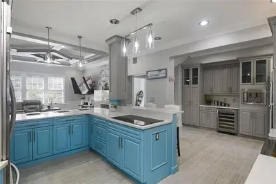 a large kitchen with blue cabinets and white counters at LUXURY 6000 sqft Mansion in Downtown Orlando Sleeps 12 in Orlando